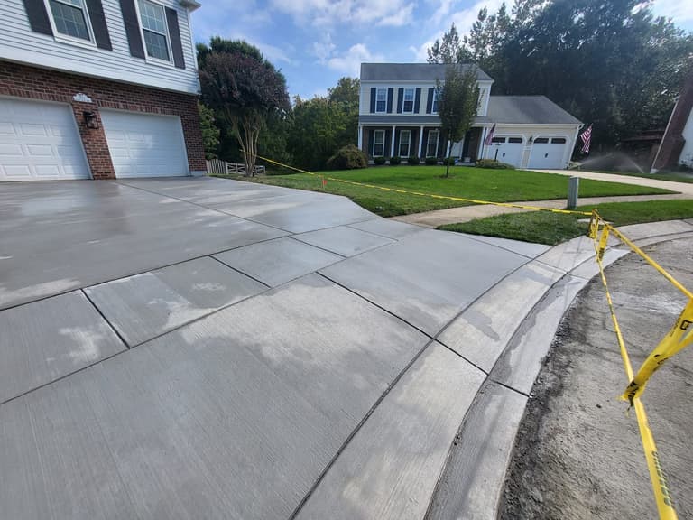 After — the curved edge of the new driveway where it meets the lawn and the street