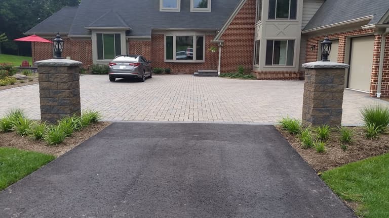 Paver parking court framed by stone entry pillars in Davidsonville